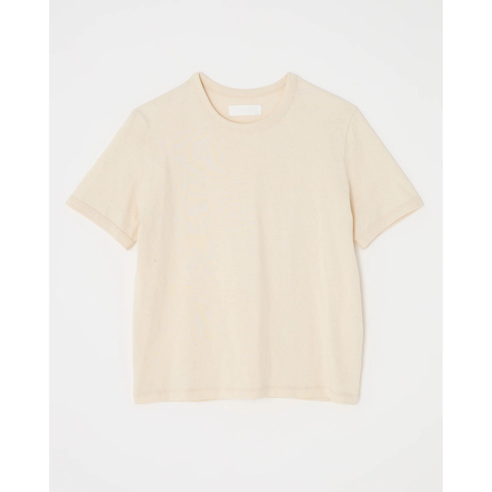 Front flat lay view of the short-sleeve "Basic Tee" in off-white crewneck cotton jersey against a light neutral background.