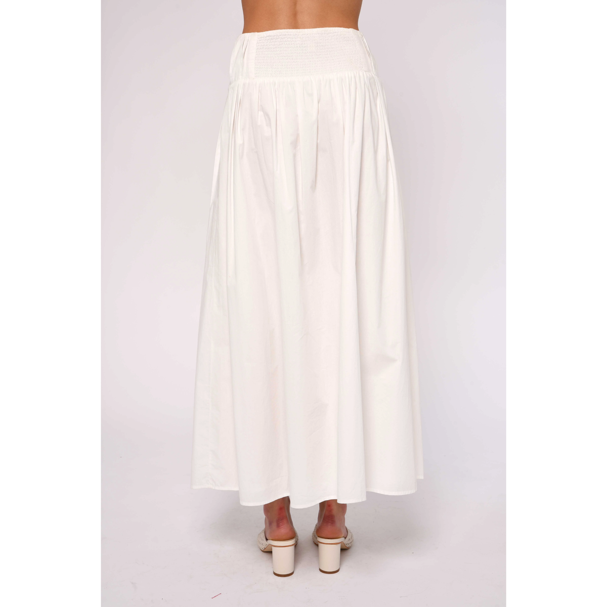 White skirt worn by a person on a white background