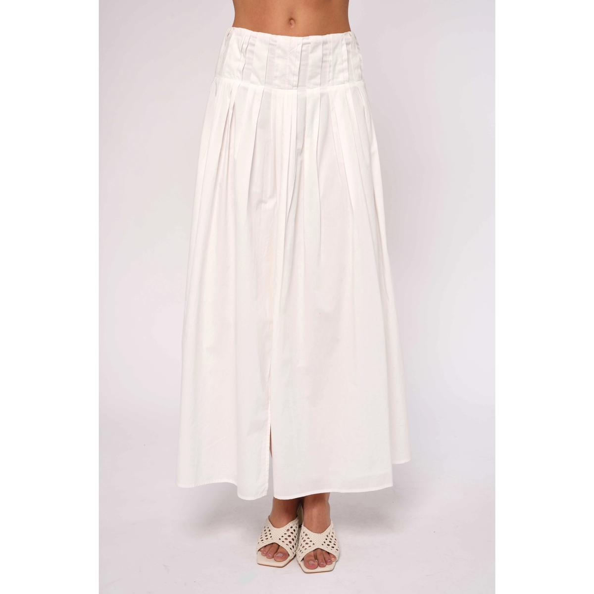 White skirt worn by a person on a light gray background