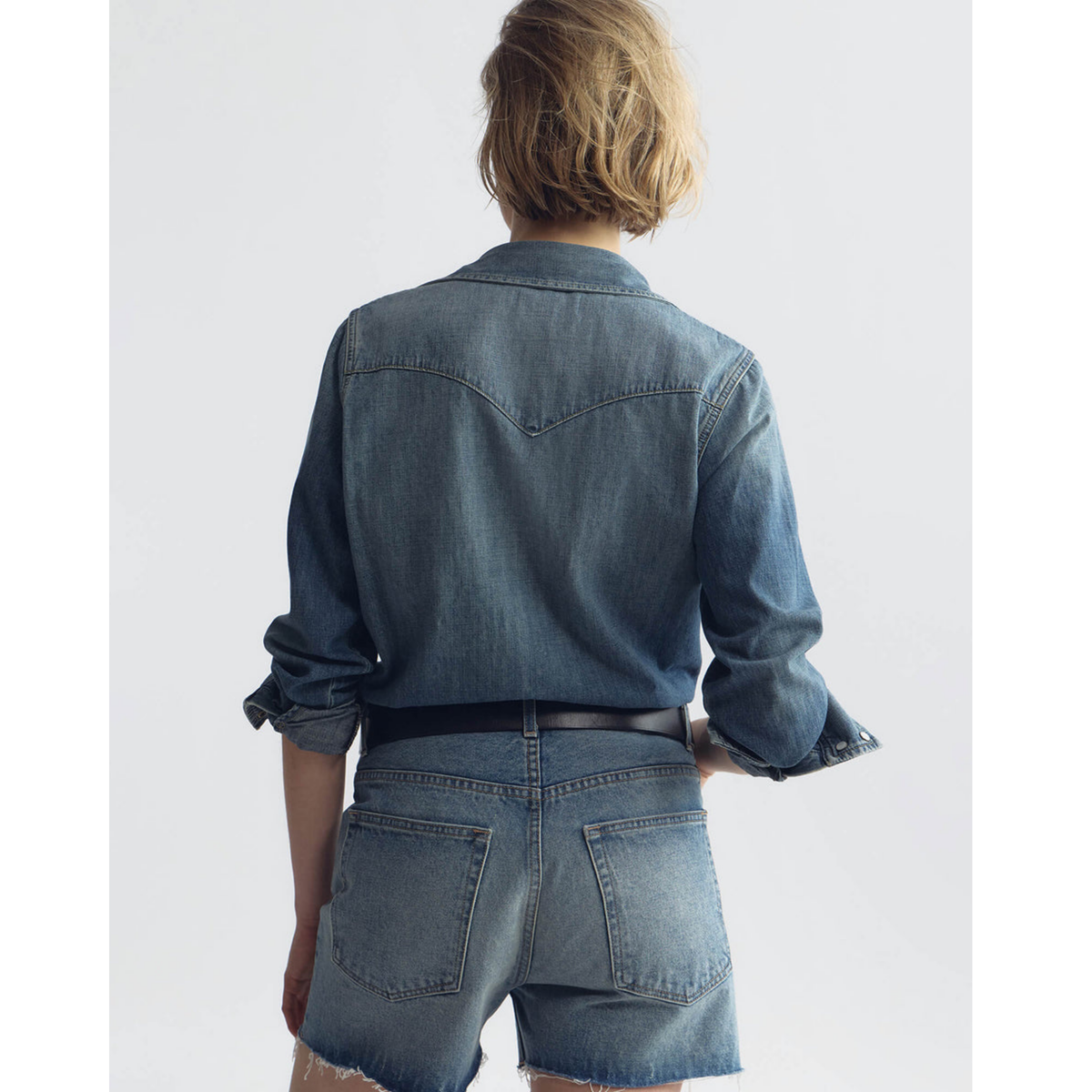 Person wearing a denim outfit on a plain background
