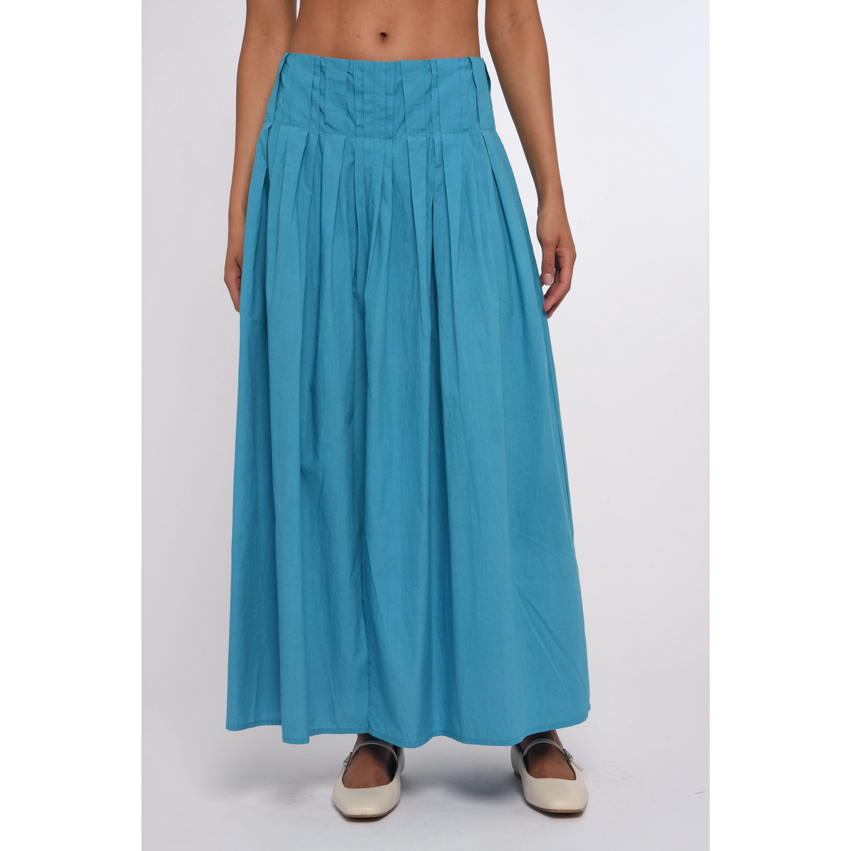 Person wearing a long blue skirt on a white background