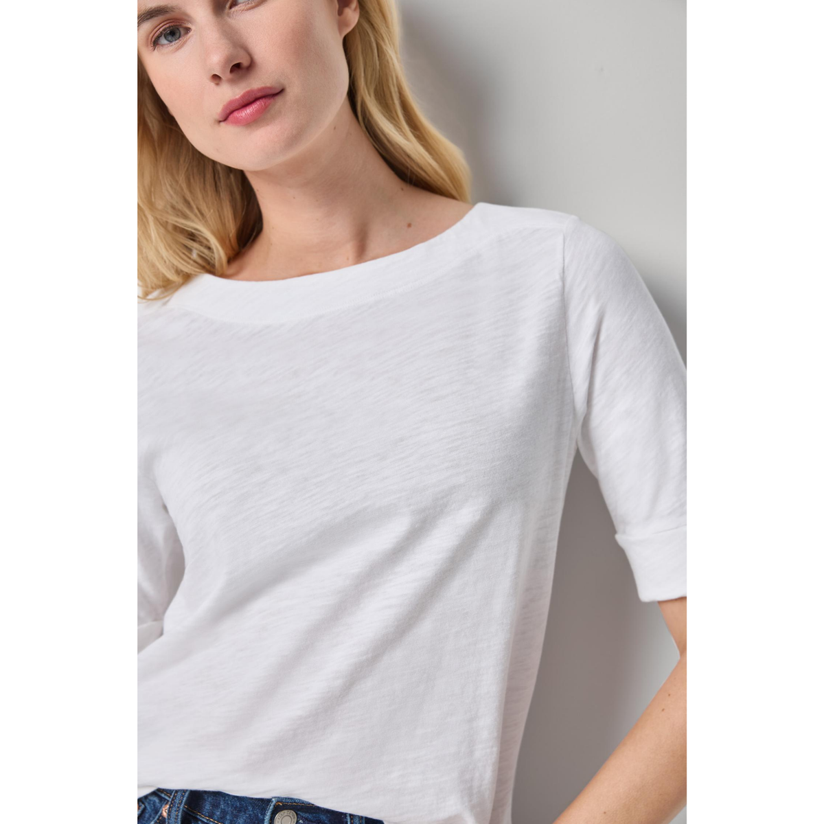 Woman wearing a plain white t-shirt against a neutral background