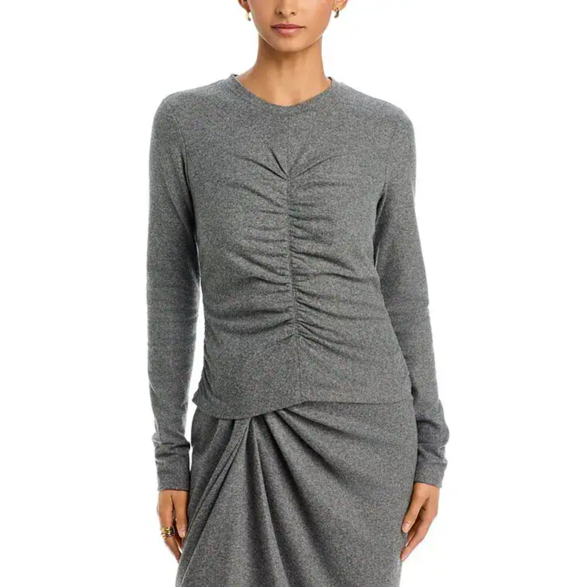 A woman wearing a heather gray long-sleeve knit top and matching draped skirt against a plain white studio background.