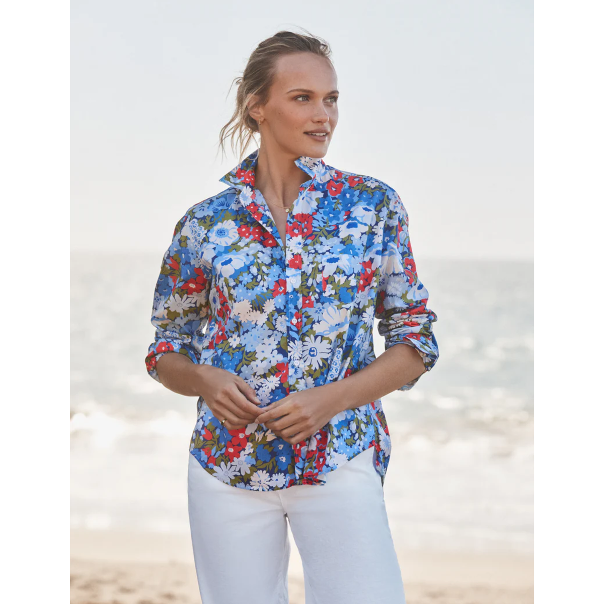 Woman wearing a colorful floral shirt on a beach