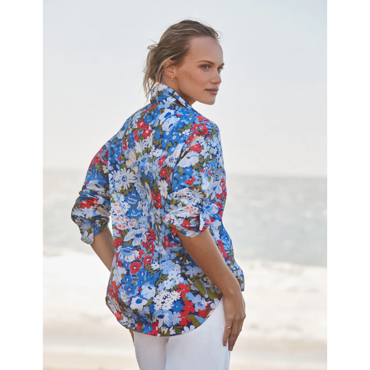 Woman wearing a colorful floral shirt on a beach