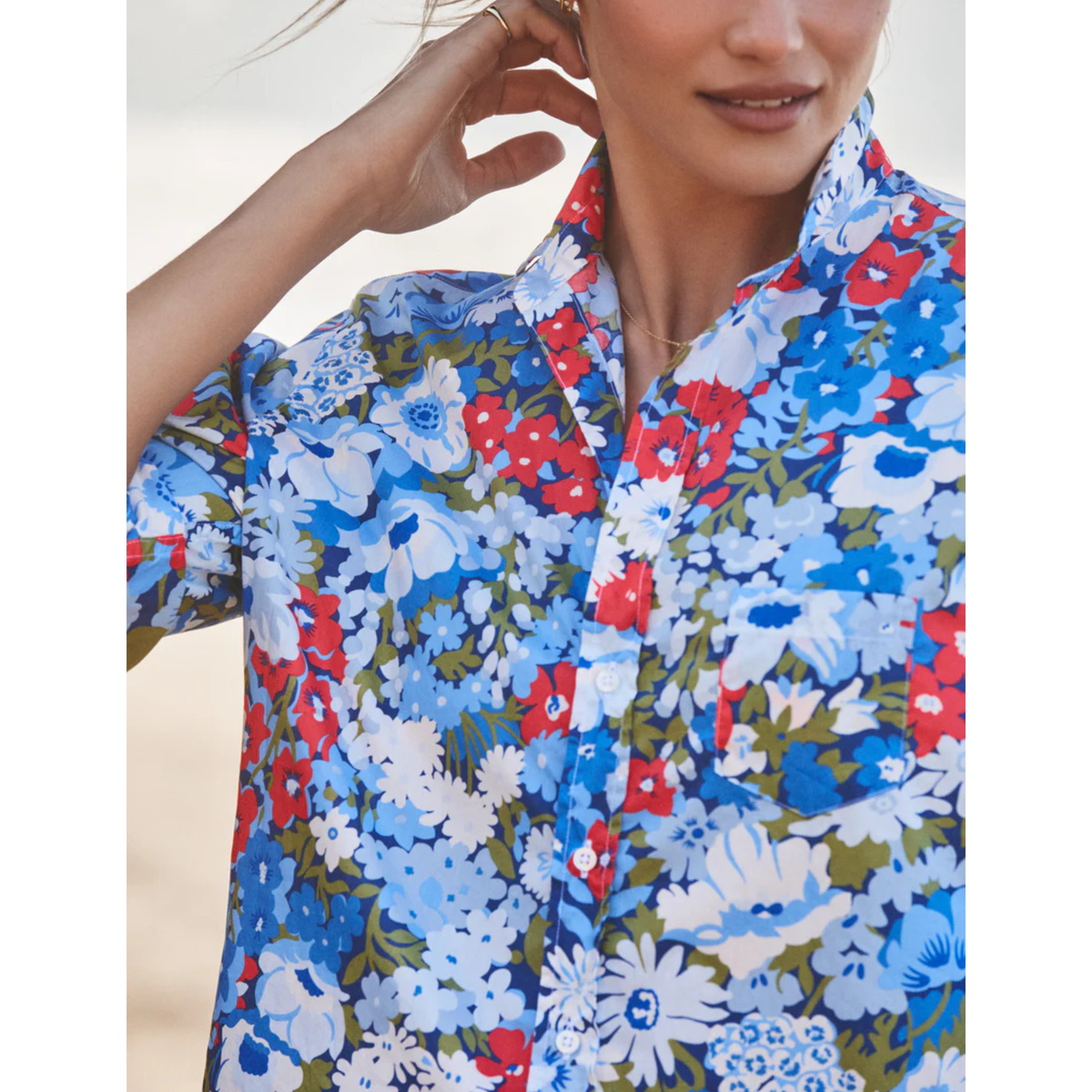 Woman wearing a colorful floral shirt with a blurred background