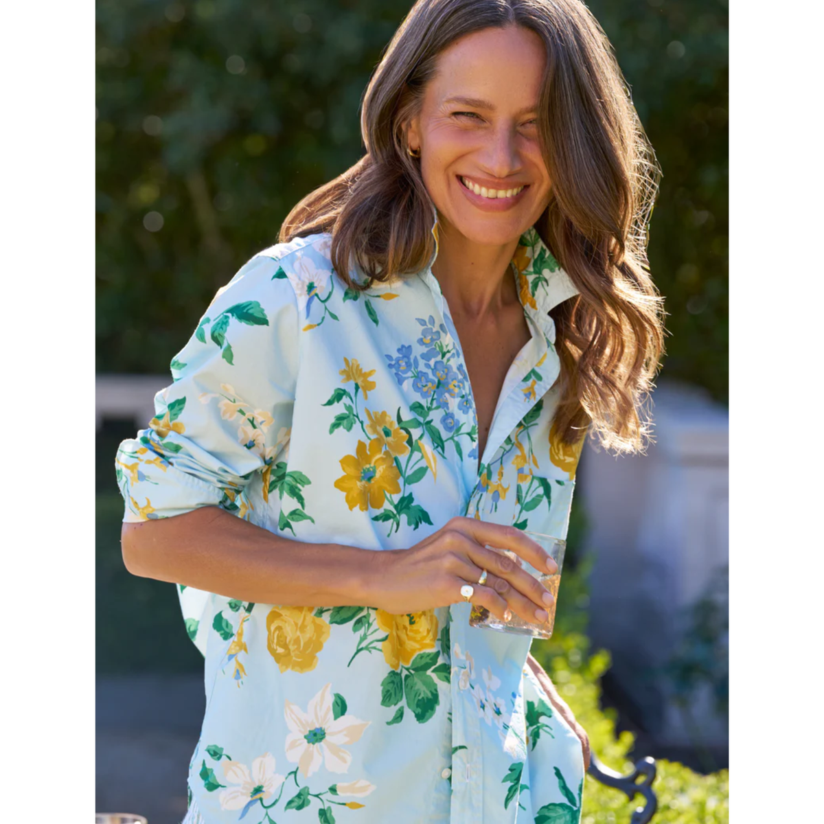 Woman wearing a floral dress with a blurred outdoor background