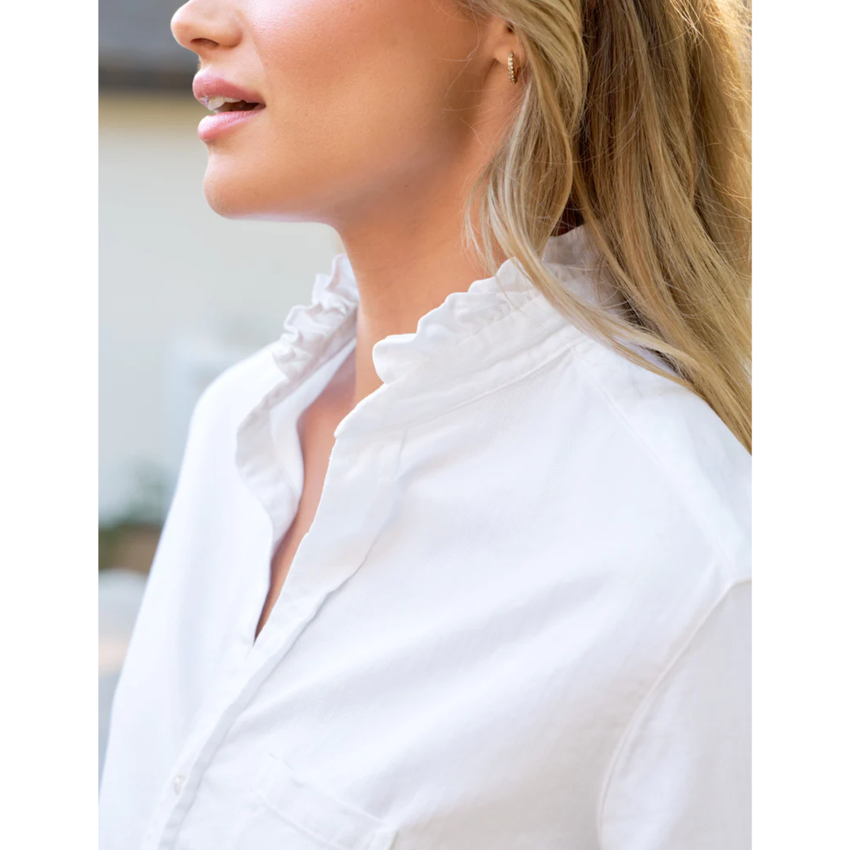 Close-up of a person wearing a white shirt with a blurred background