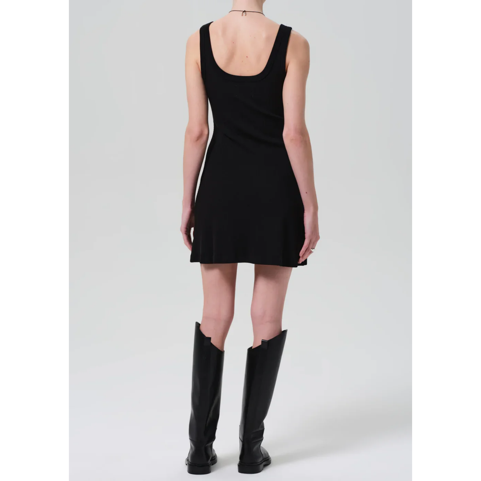 Black sleeveless dress worn by a person on a plain background