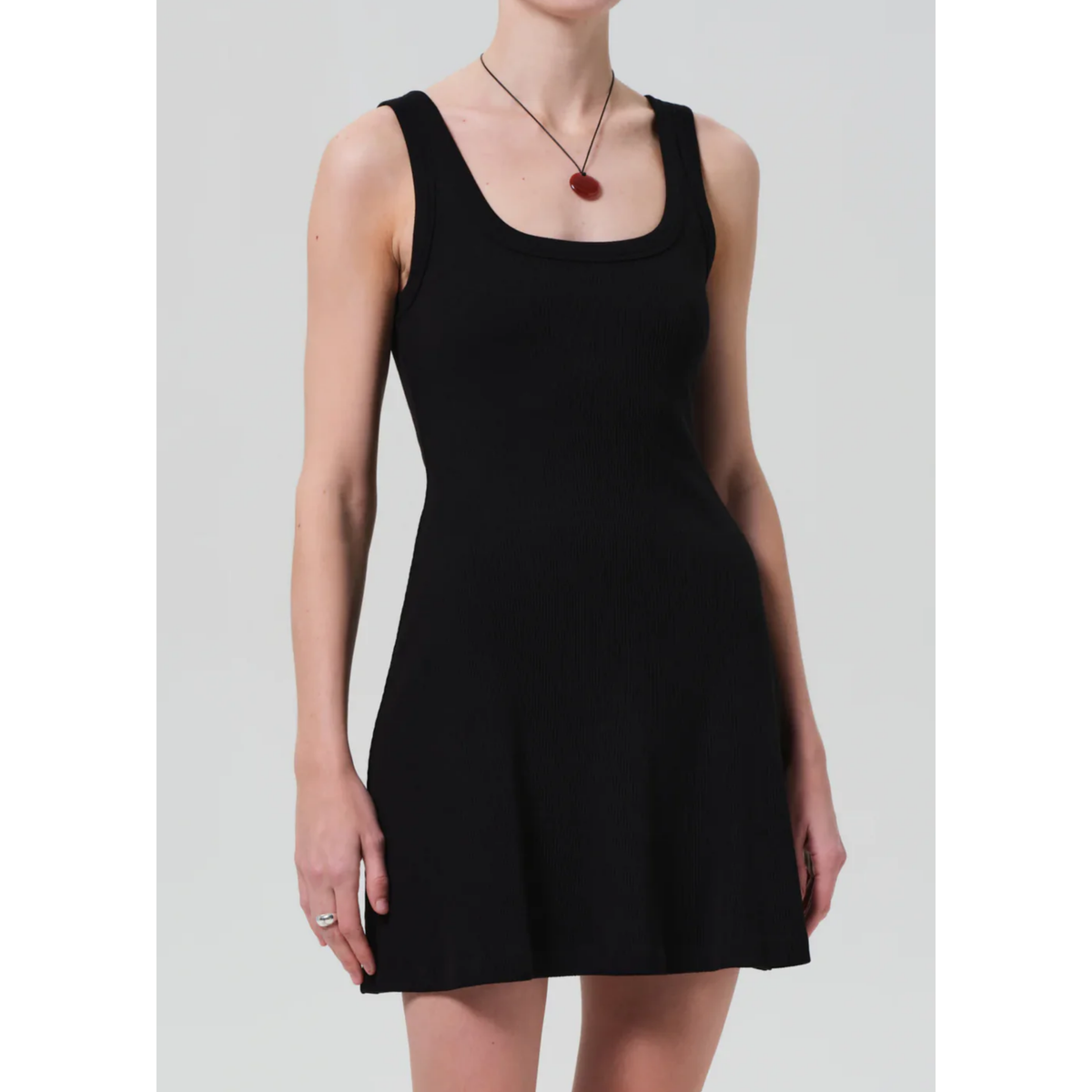 Black sleeveless dress worn by a person on a plain background