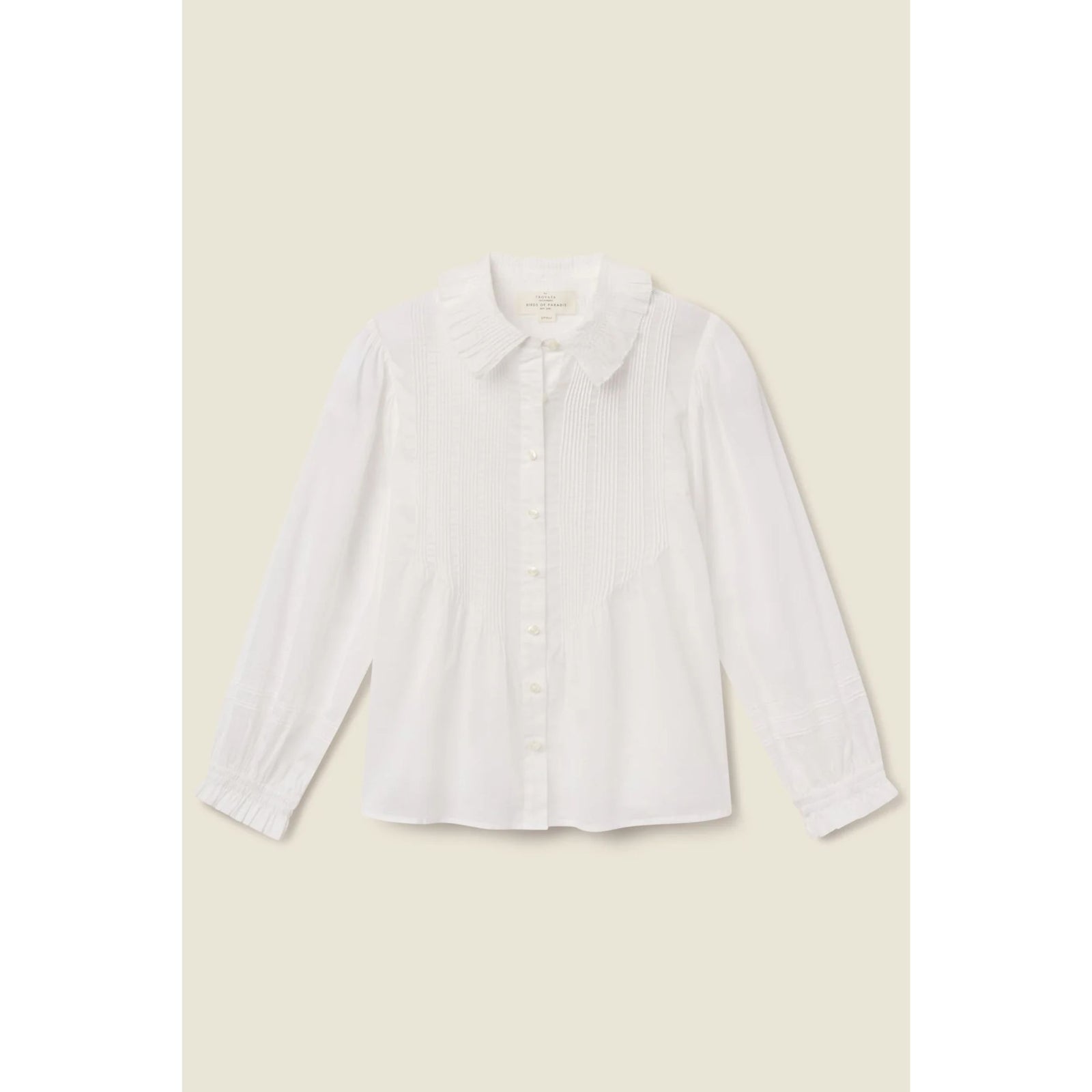A white long-sleeve button-up blouse with a Peter Pan collar, shown flat against a light beige background.