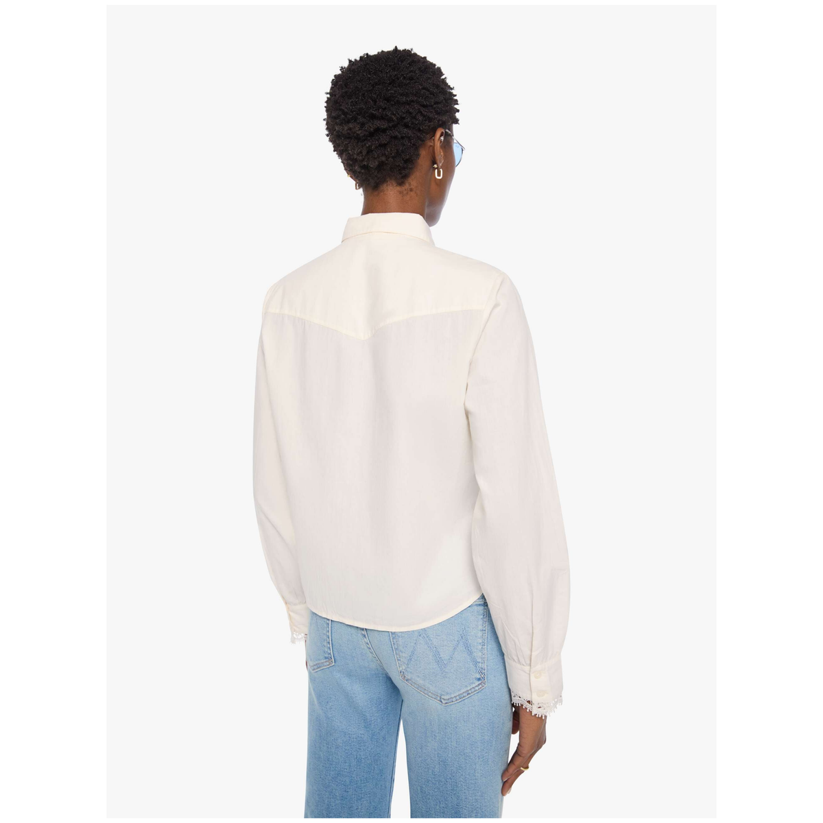 A model shown from the back wearing a white long-sleeve button-up shirt and light blue jeans against a plain white background.