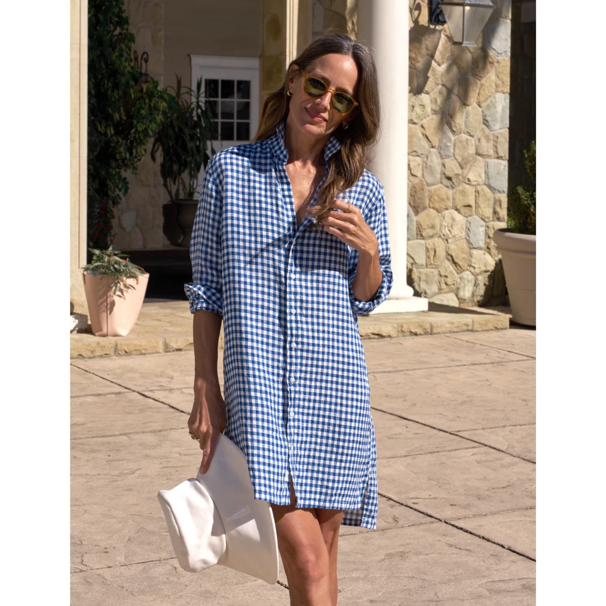 Woman wearing a blue and white checkered dress outdoors.