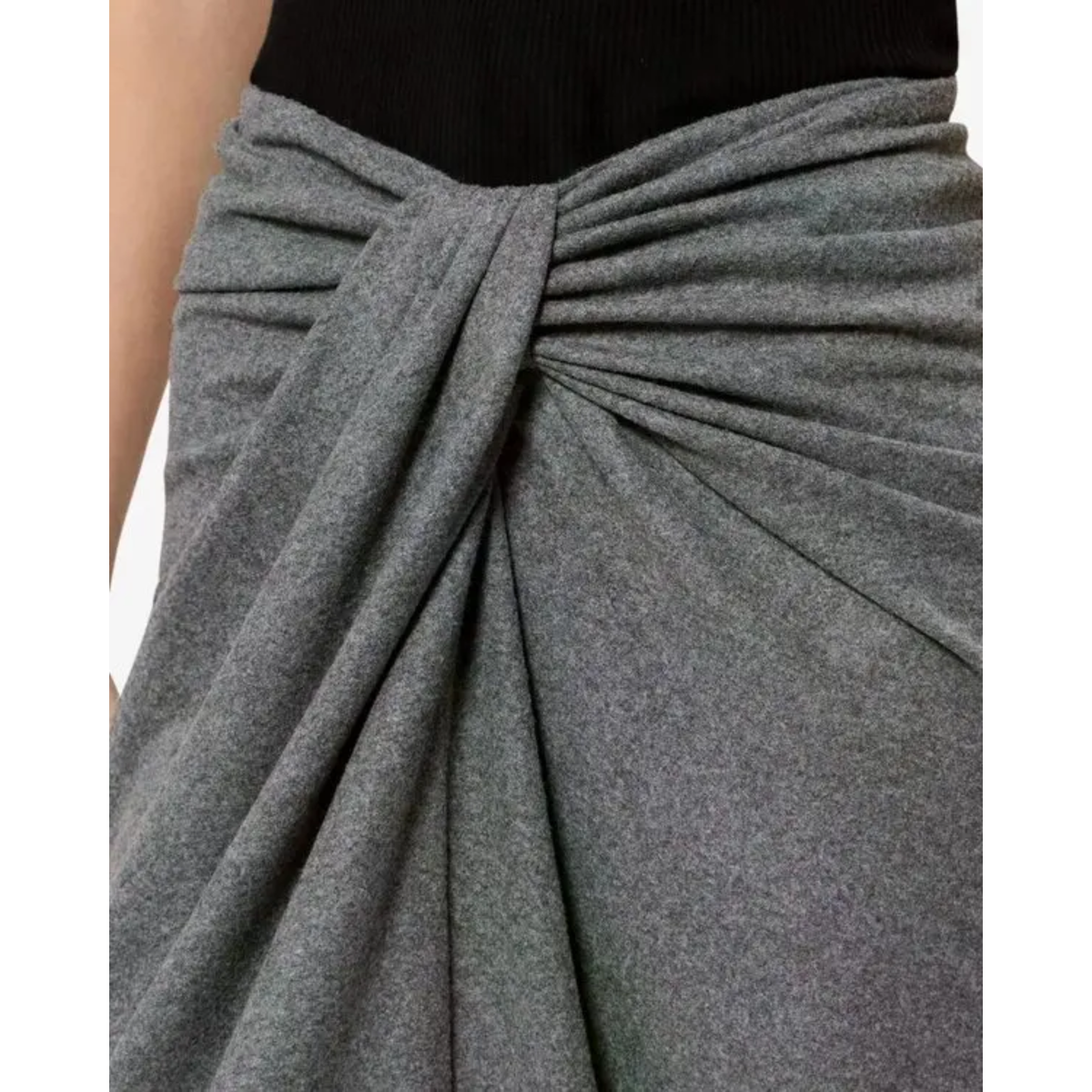 Close-up of a gray draped wrap skirt tied at the waist over a black top, showing the fabric texture and gathered draping detail.