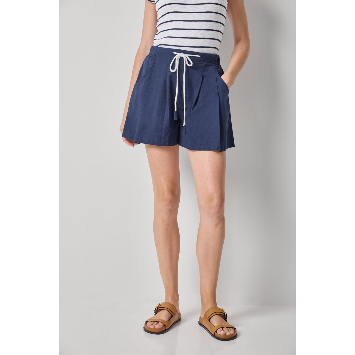 Person wearing a navy blue skirt with a white background