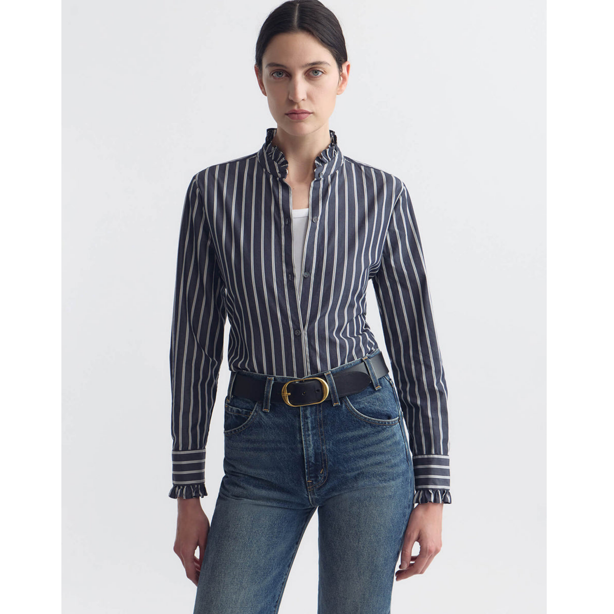 Woman wearing a striped shirt and jeans on a white background