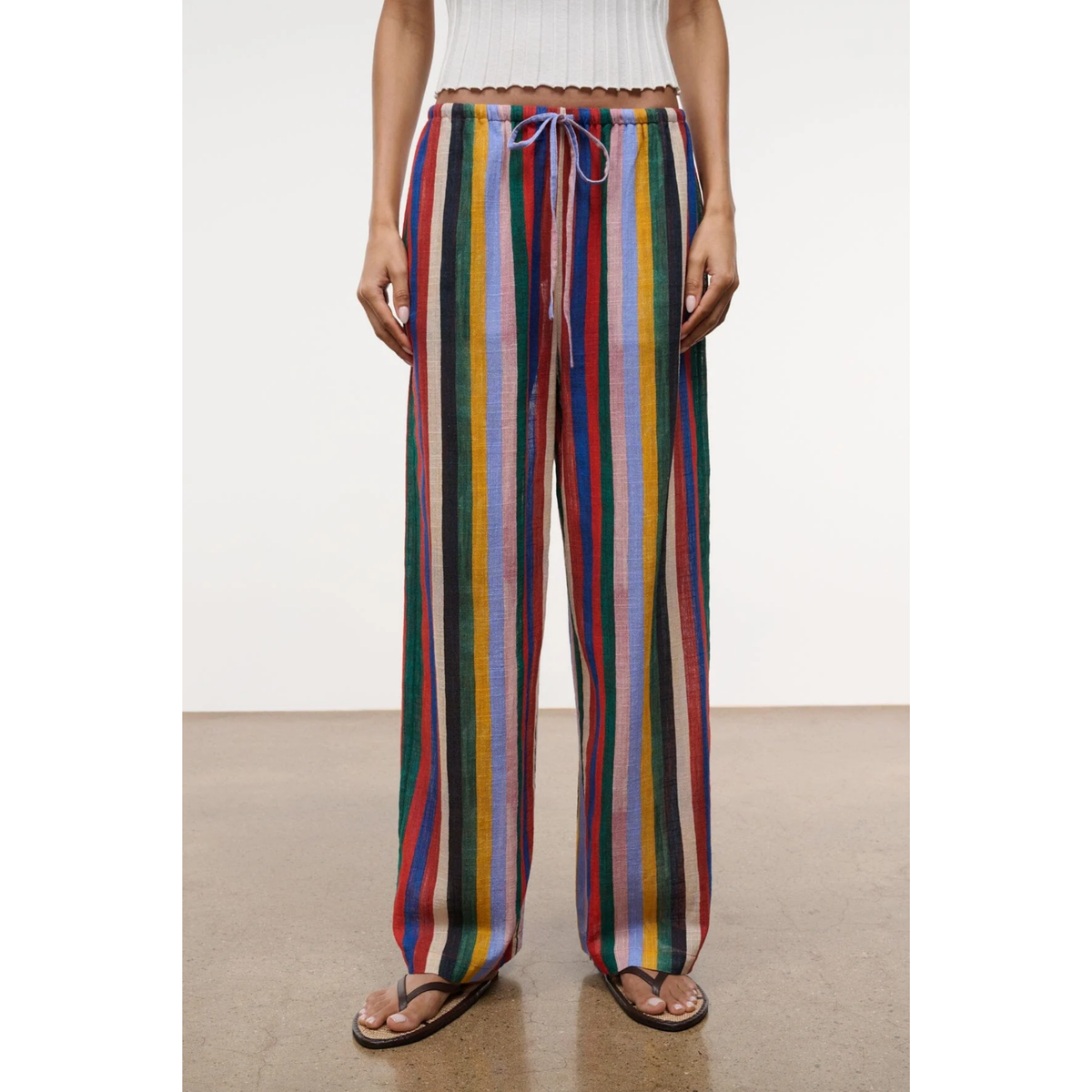 Person wearing colorful striped pants on a plain background