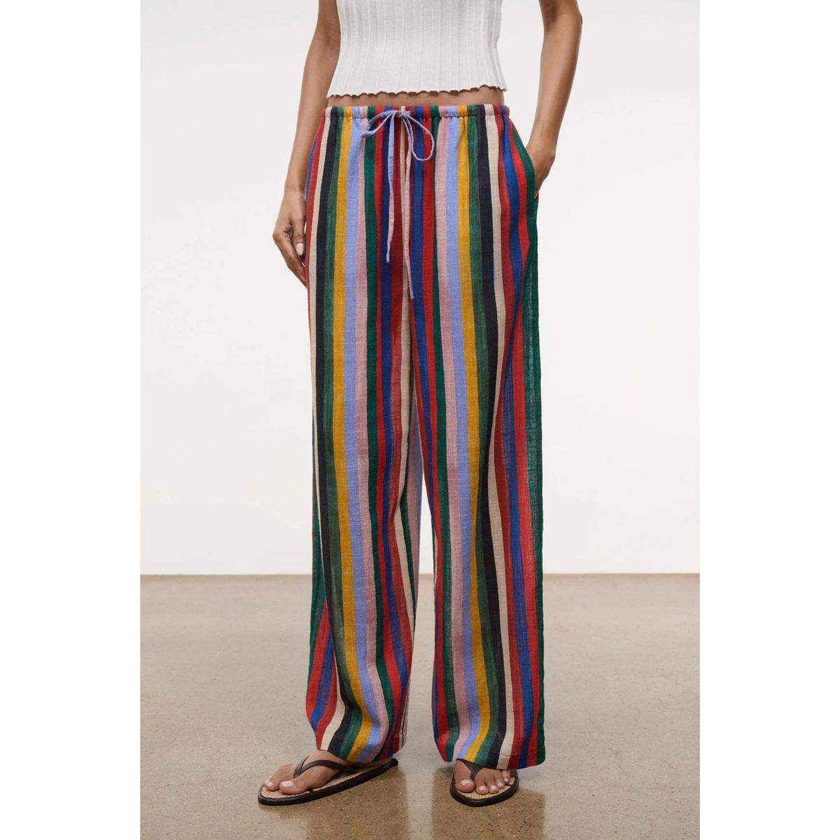 Multicolored striped pants worn by a person on a white background