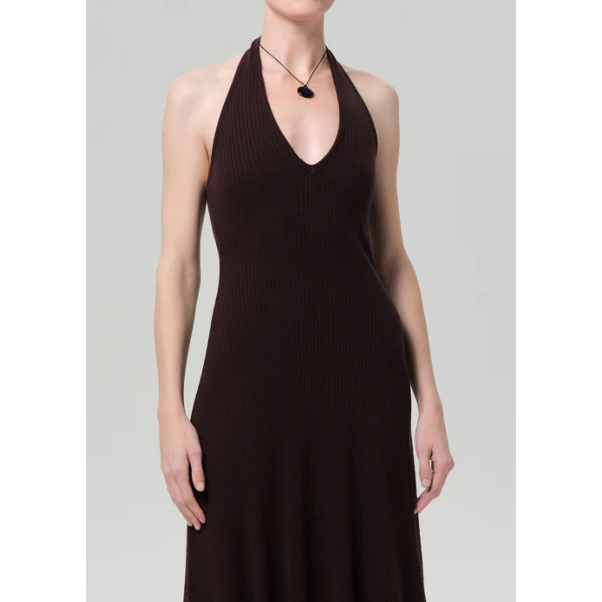 Woman wearing a brown halter neck dress on a gray background