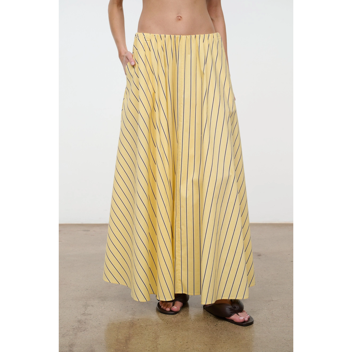 Person wearing a yellow striped skirt on a plain background