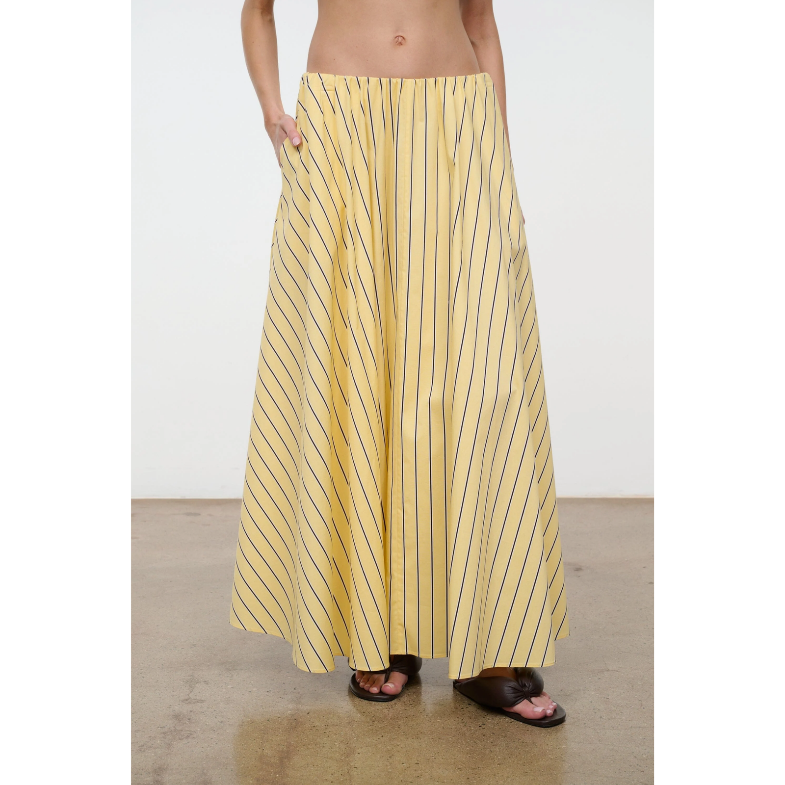 Person wearing a yellow striped skirt on a plain background
