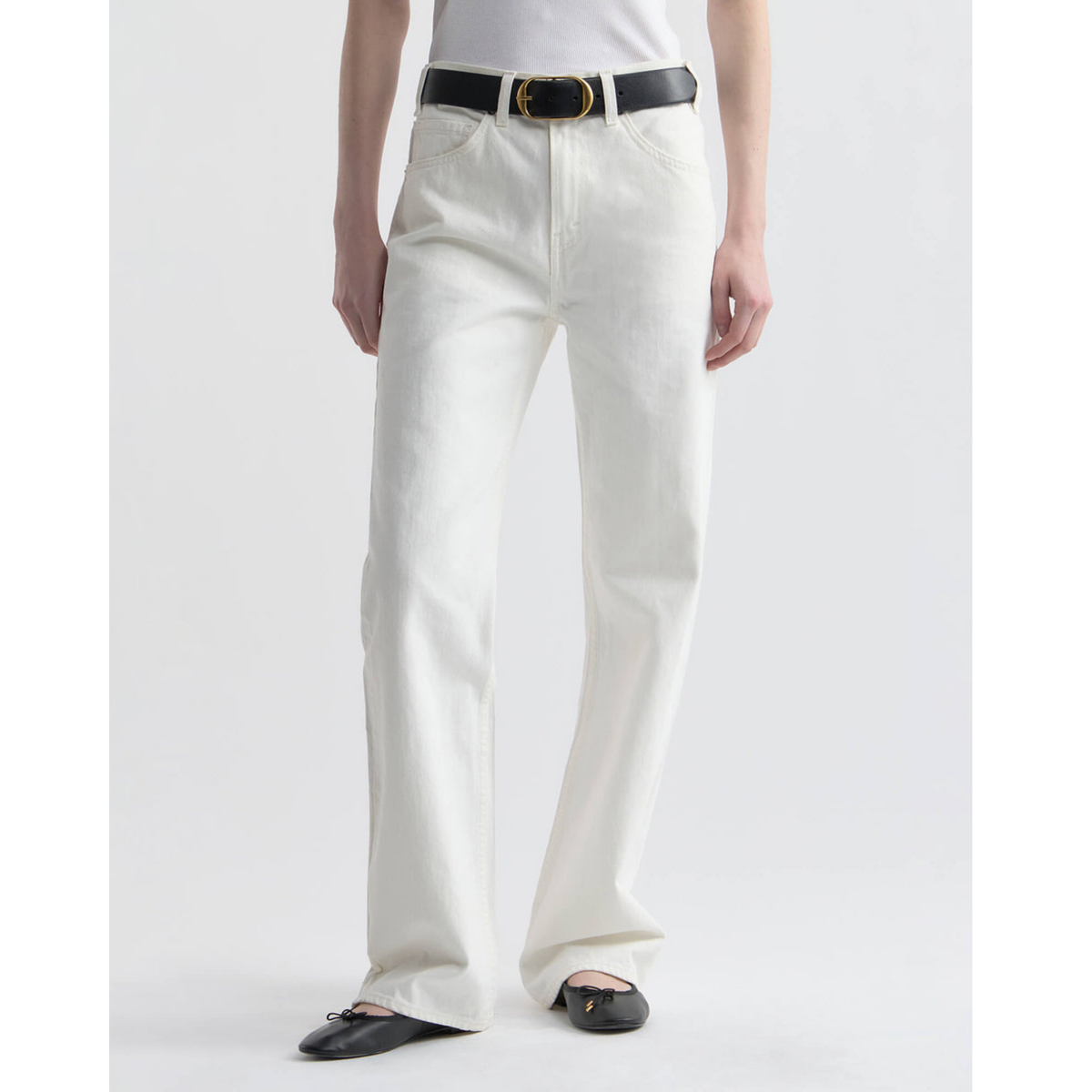 Person wearing white pants with a black belt on a light gray background