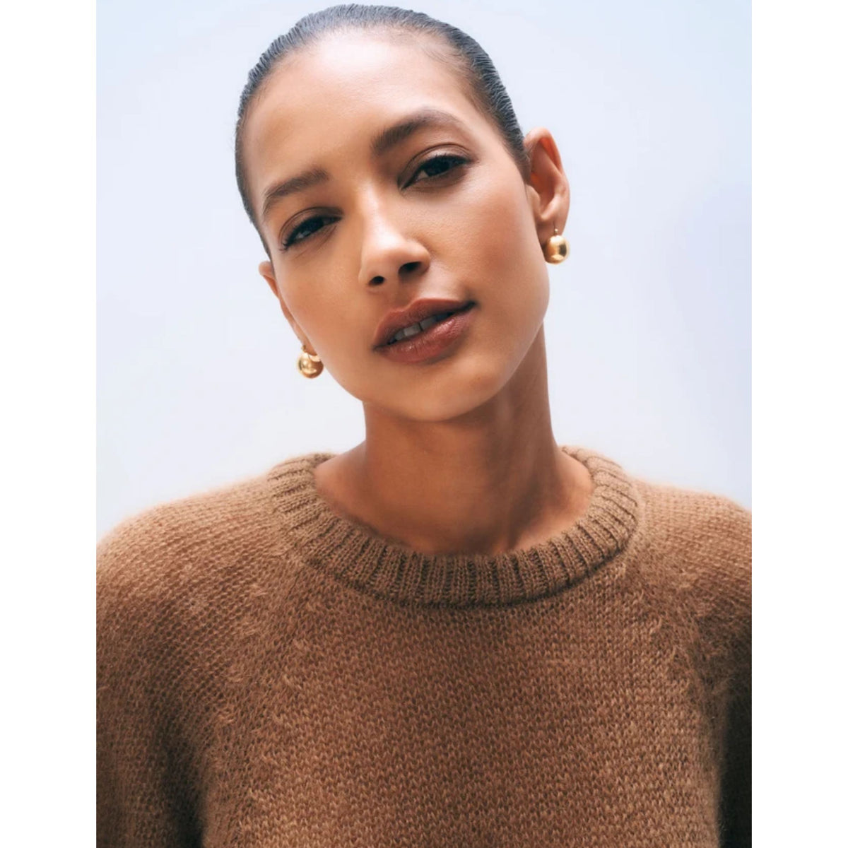 Close-up portrait of a model wearing the crewneck Camel brown mohair-blend sweater tee.