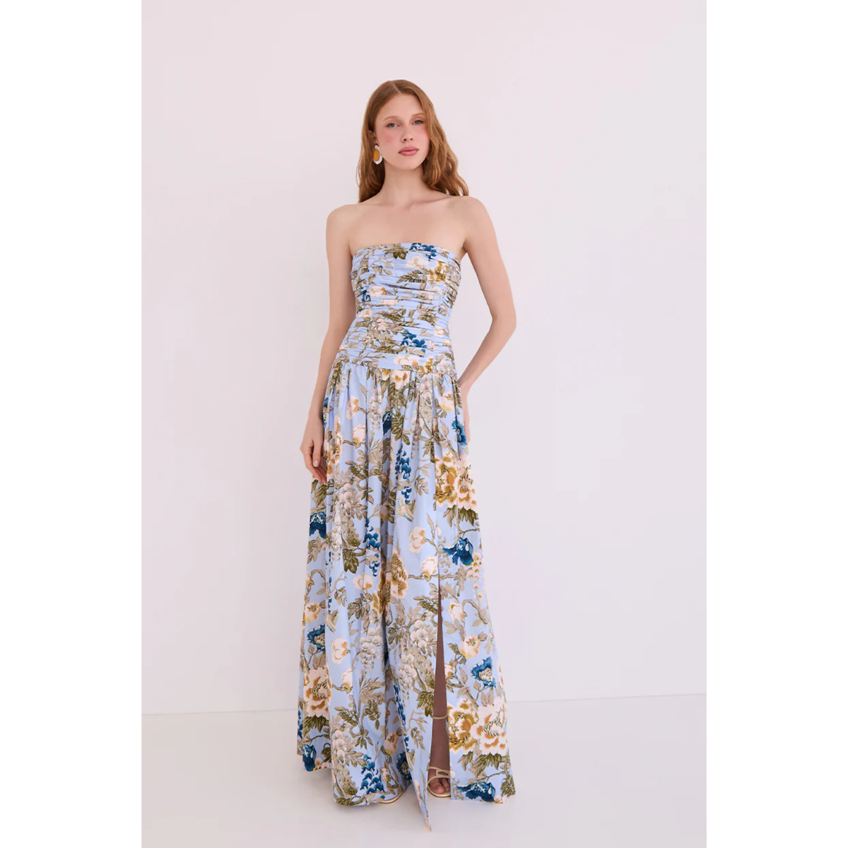 Woman wearing a floral strapless gown on a white background