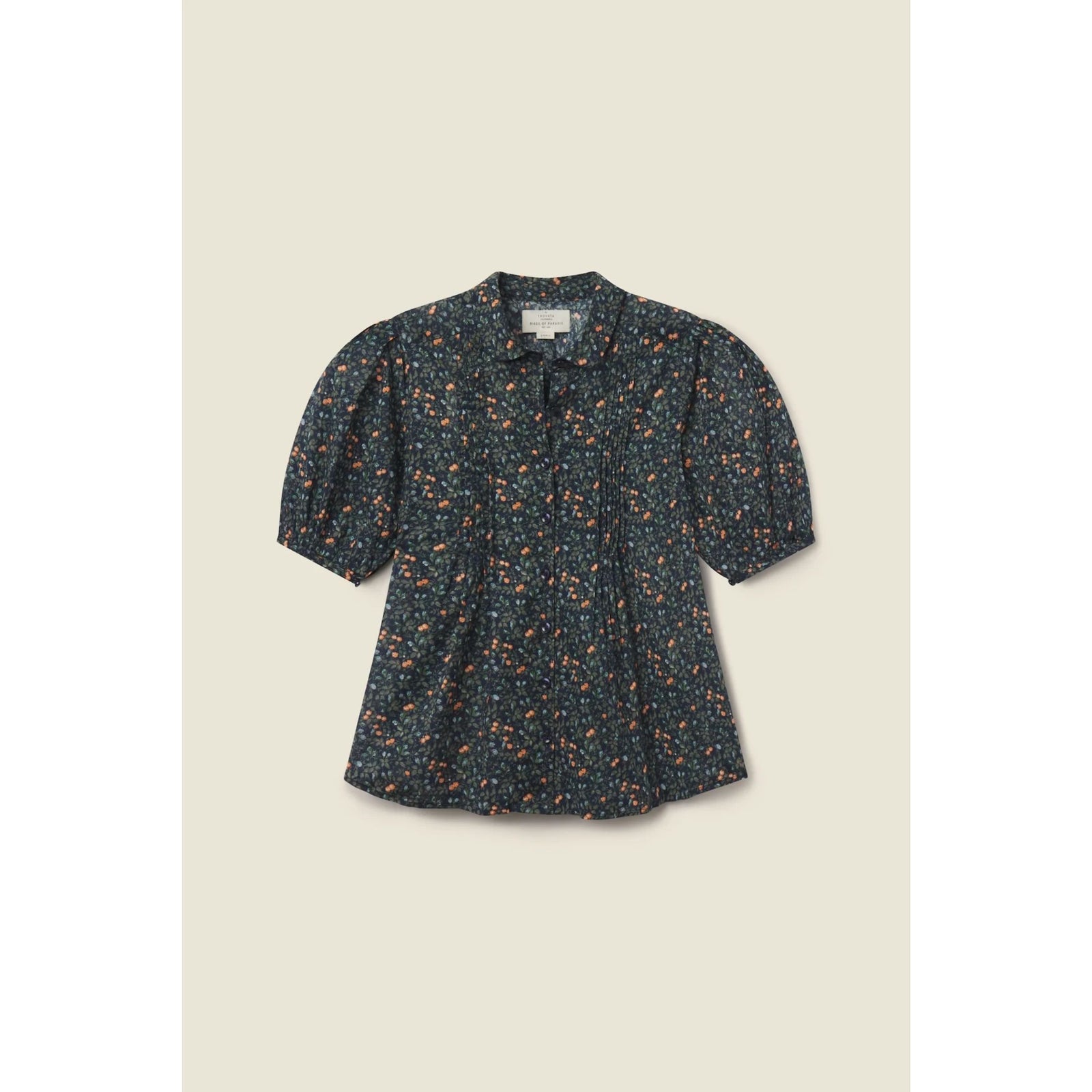 A short-sleeve blouse with a dark navy blue base and a dense orange and yellow floral print, featuring puff sleeves and a small bow at the collar, displayed flat against a light beige background.