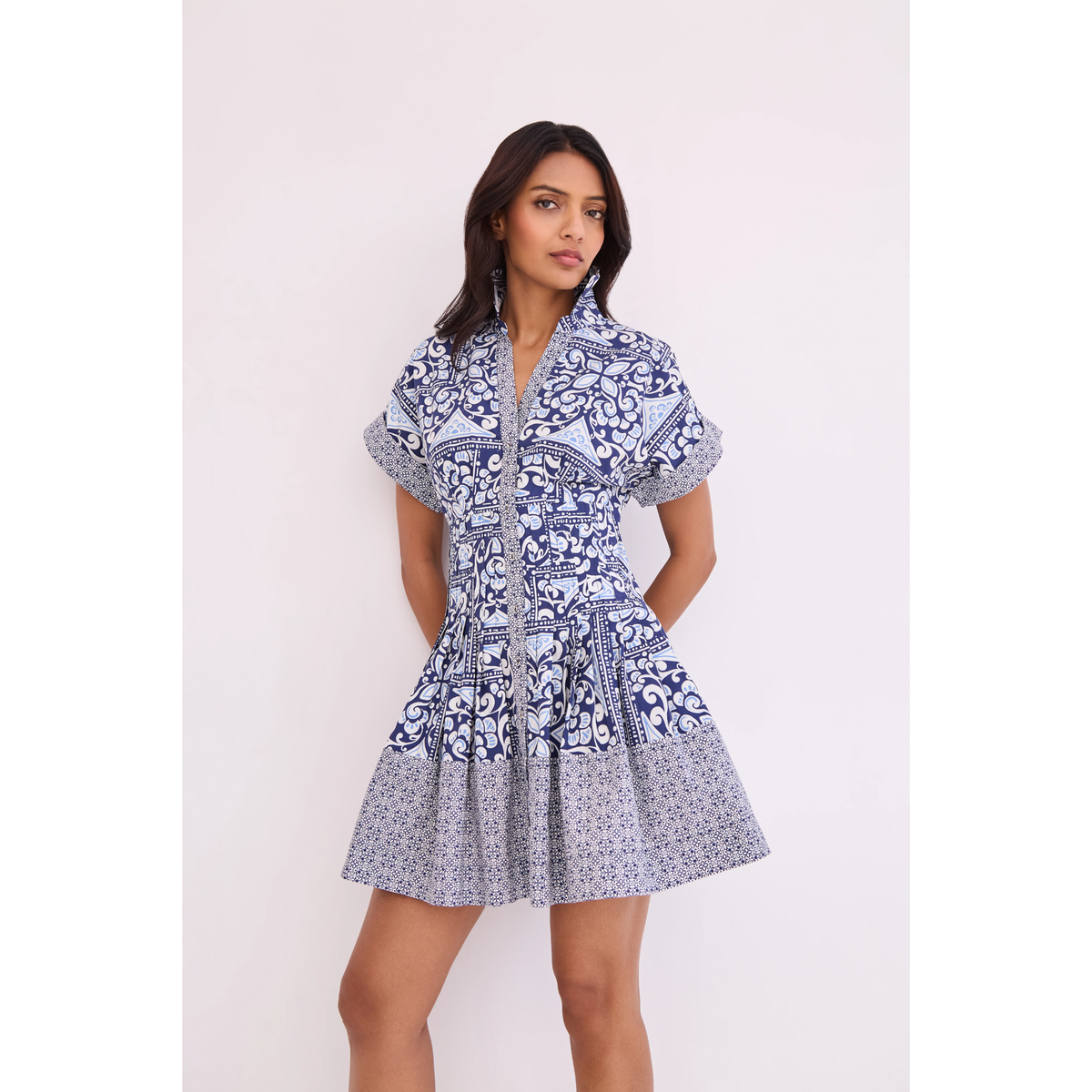 Woman wearing a blue and white patterned dress on a white background