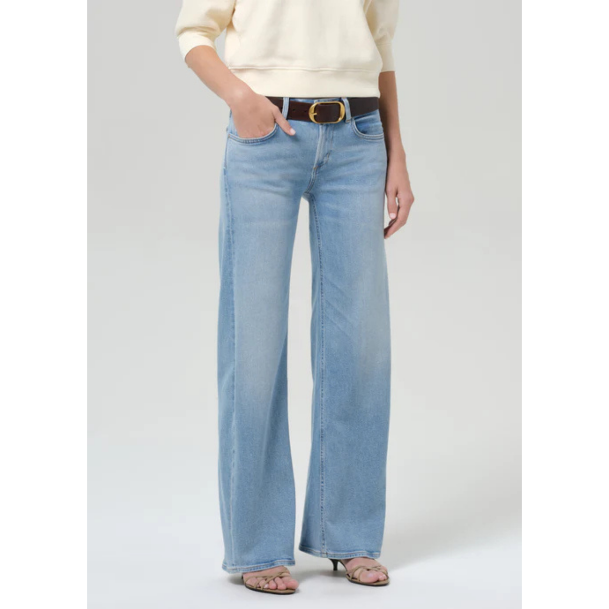 Light blue flared jeans worn by a person on a white background