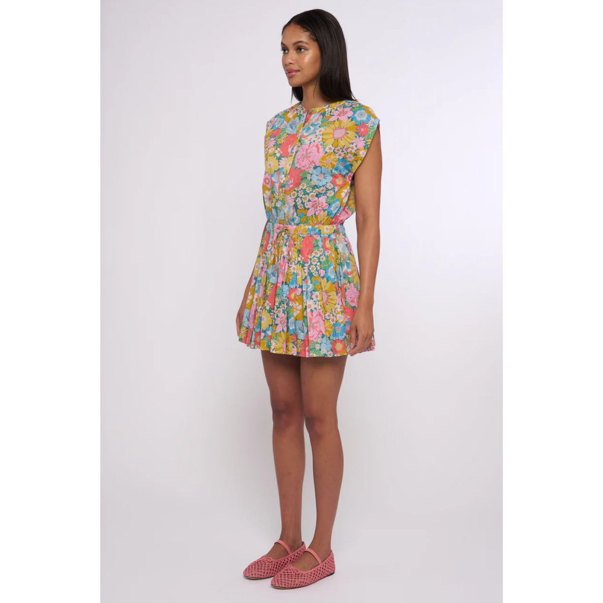 Woman wearing a colorful floral dress on a white background