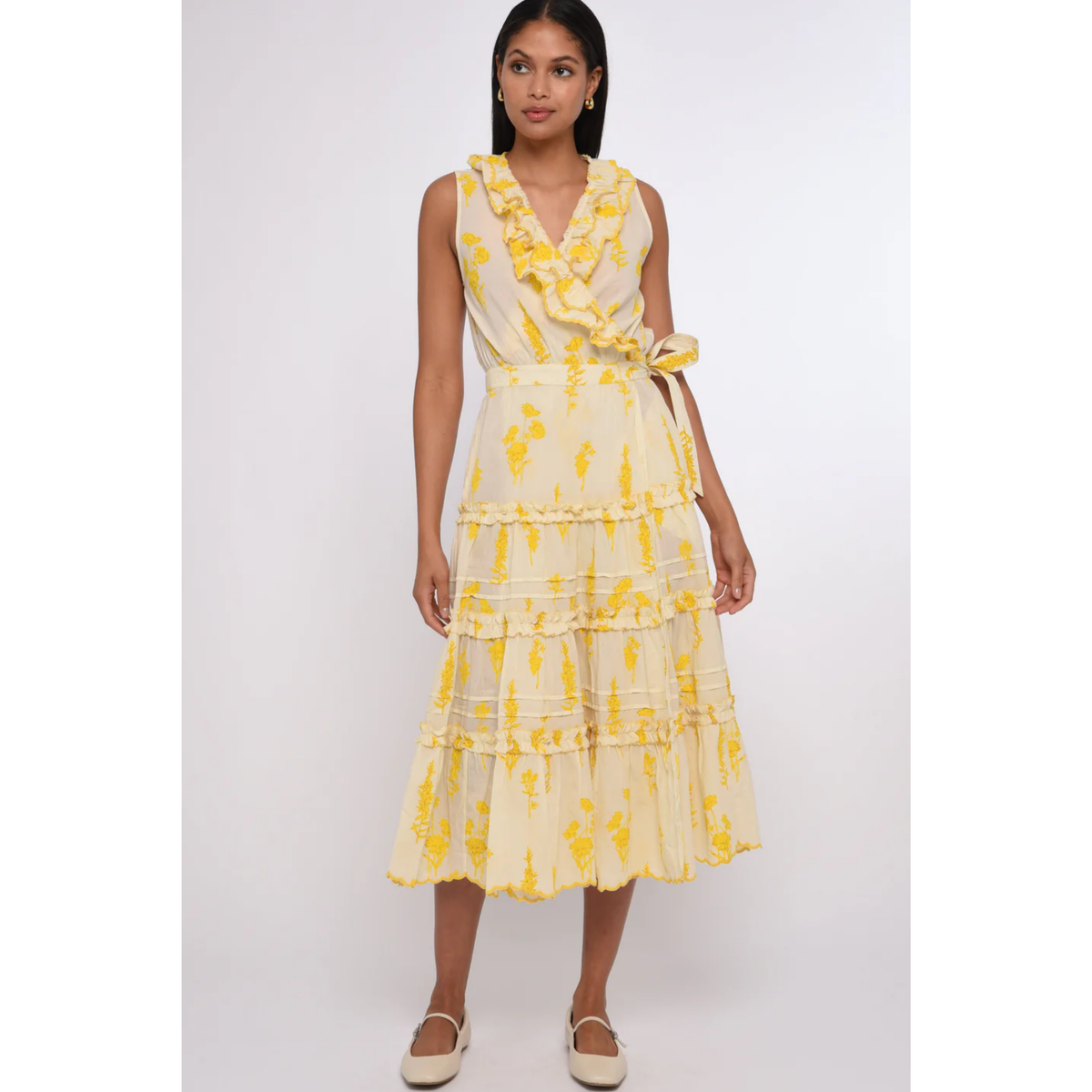 Woman wearing a yellow floral dress on a white background