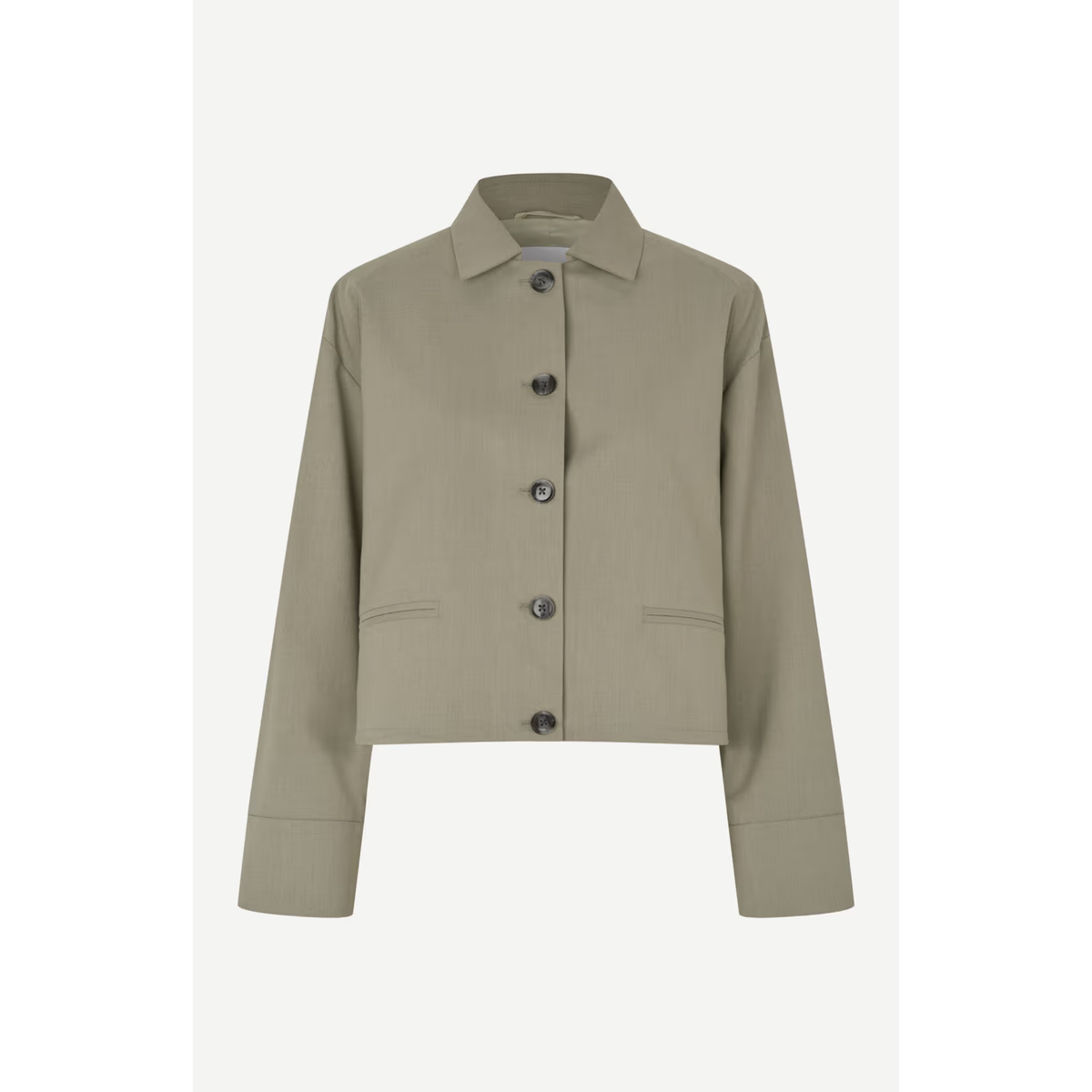 A cropped long-sleeve button-up jacket in a muted sage green color, featuring a pointed collar, dark buttons, and two front flap pockets, shown against a light gray background.