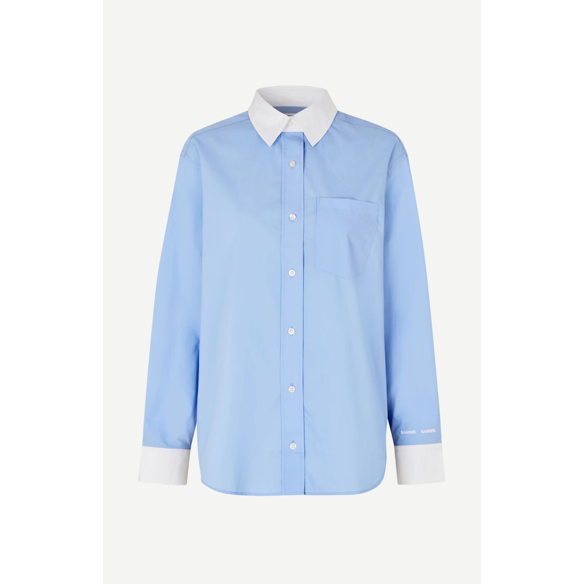A light blue long-sleeve button-up shirt with a contrasting white collar, cuffs, and front buttons, displayed on a neutral light gray background.
