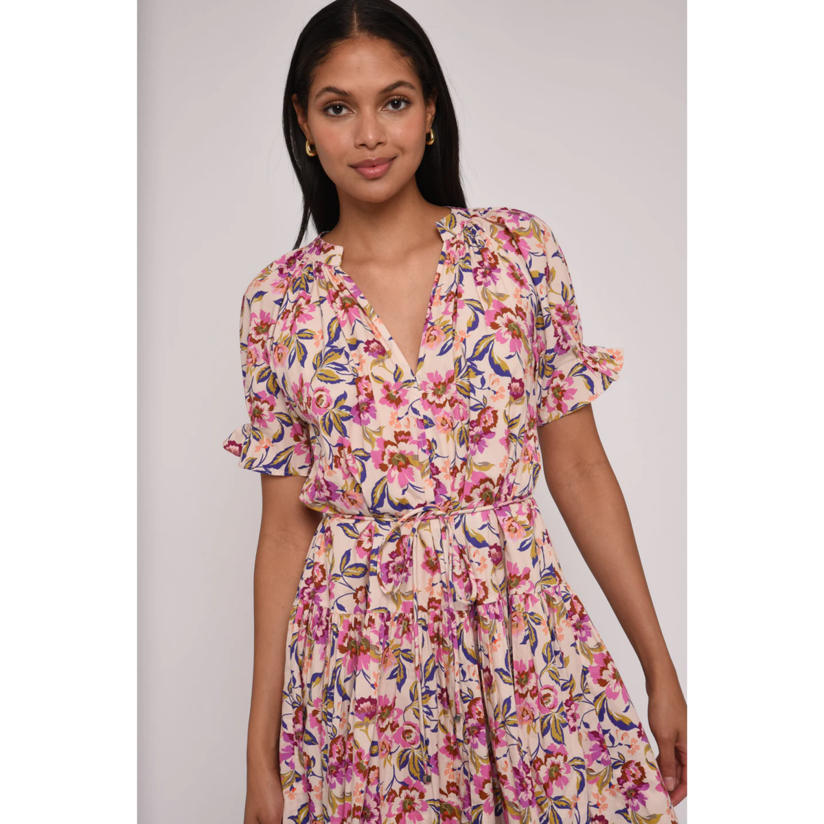 Woman wearing a floral dress against a plain background