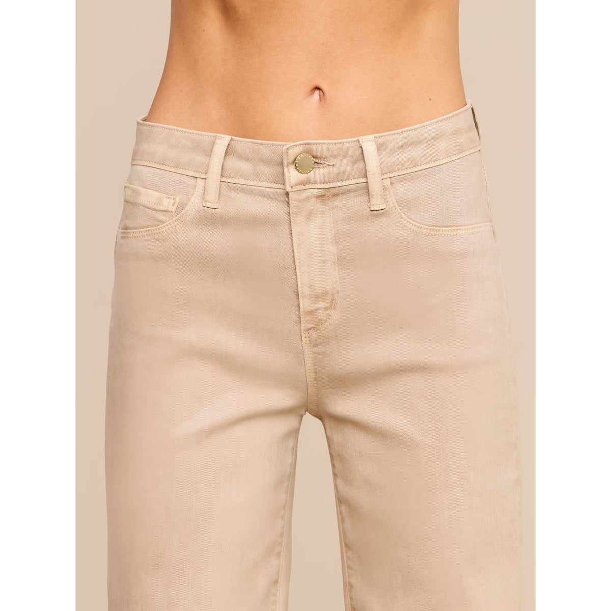 Beige cropped denim jeans shown on a model from the waist down, featuring a button closure and belt loops.