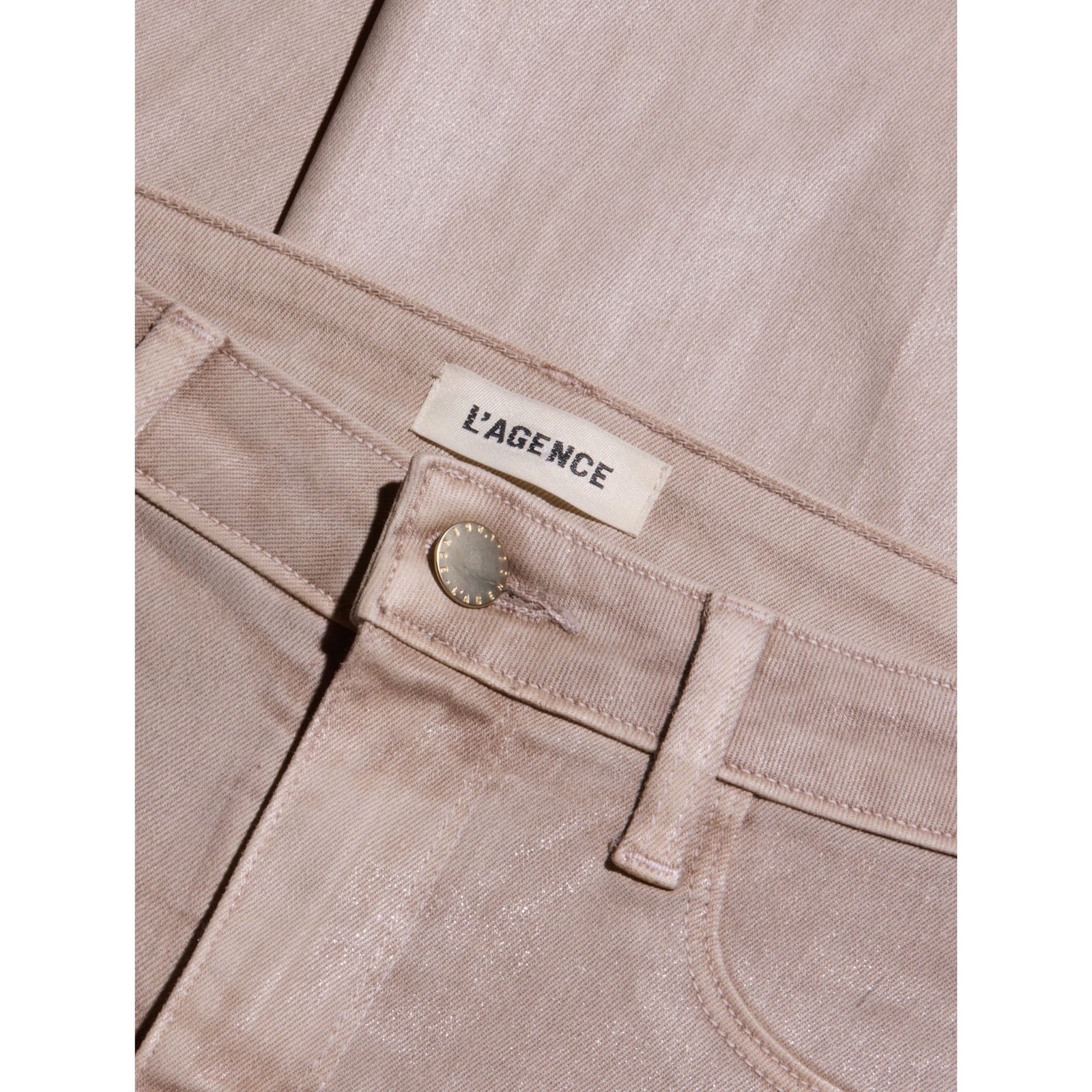 A pair of light beige straight-leg jeans displayed flat against a solid beige background.
