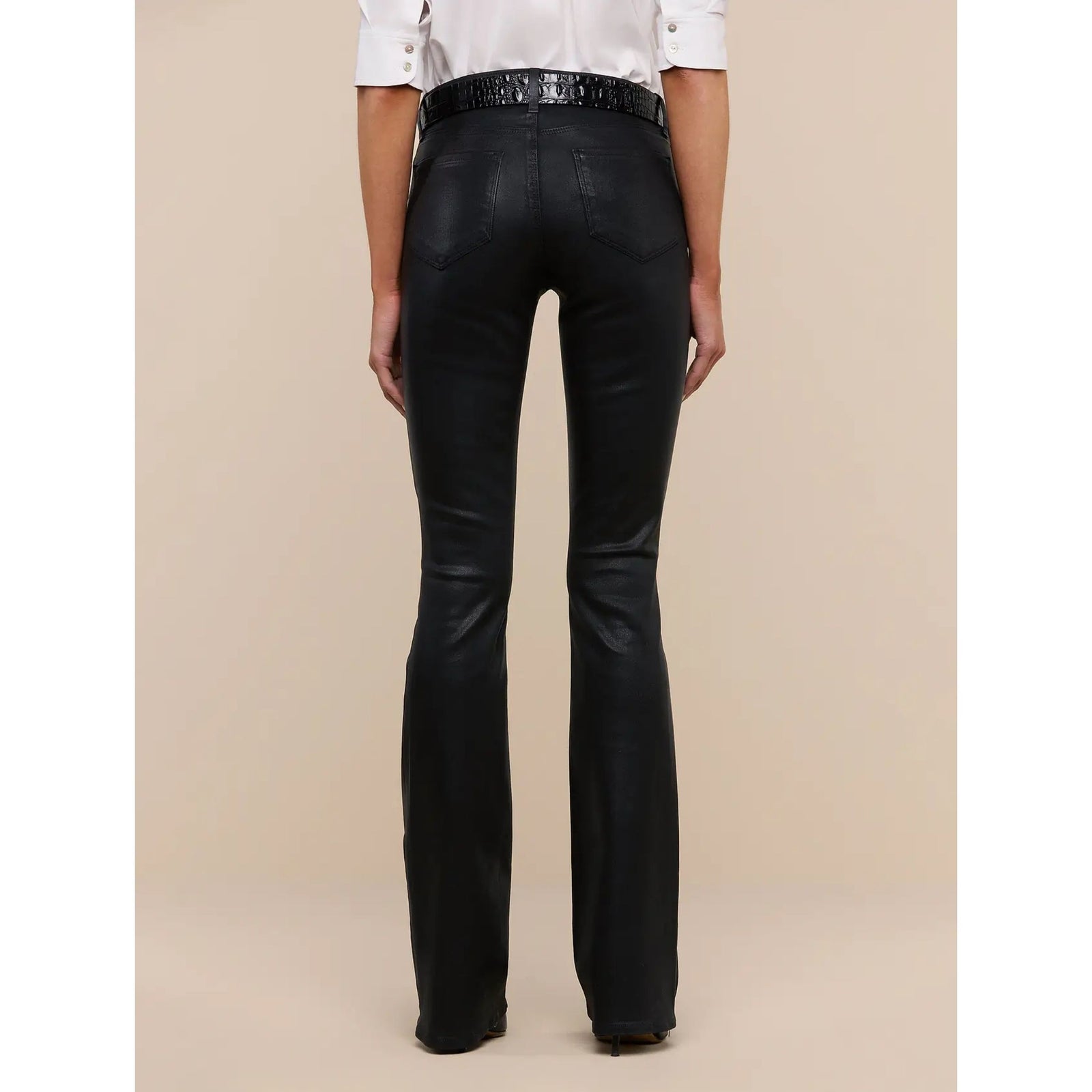 Black flared jeans displayed on a headless mannequin against a solid beige background.