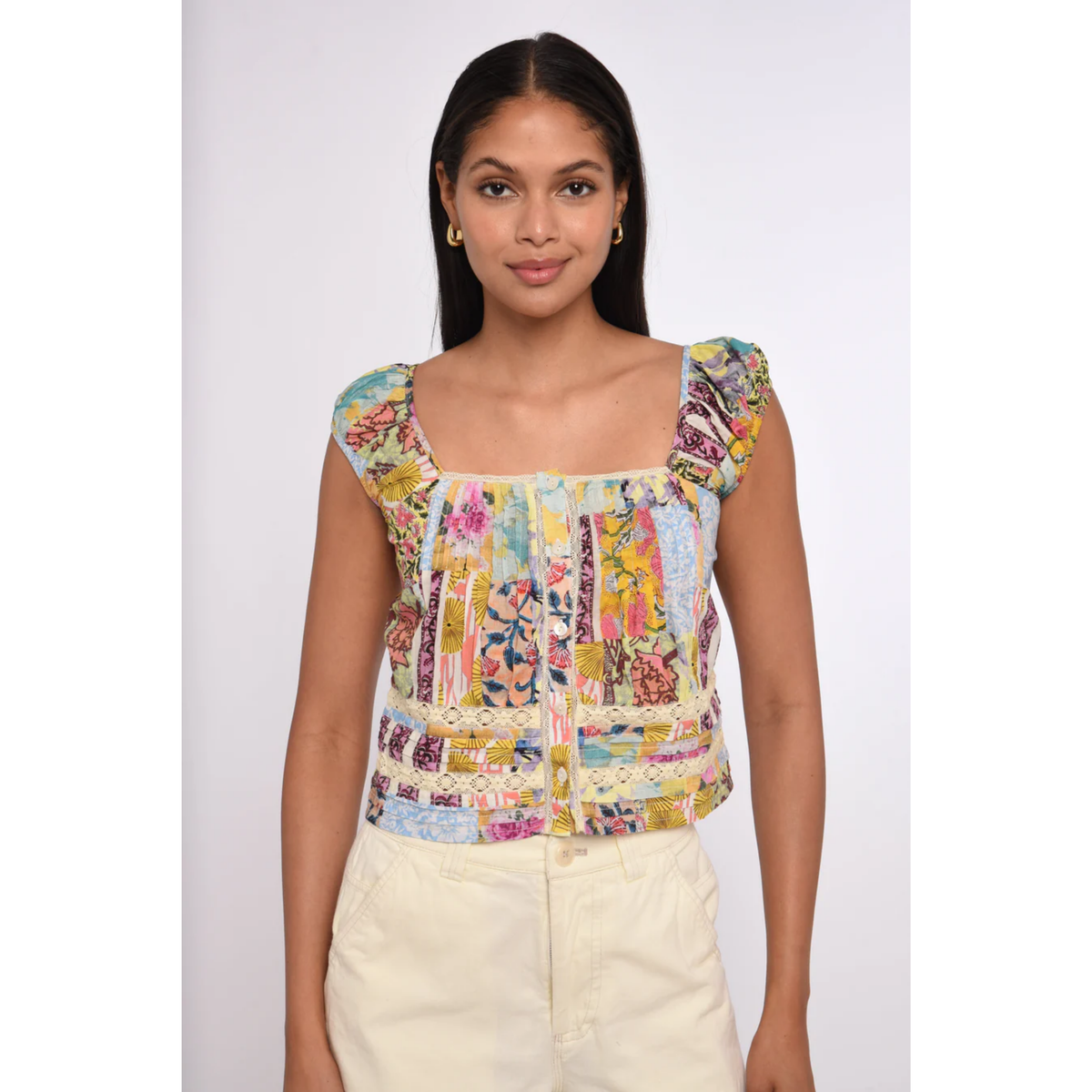 Woman wearing a colorful patterned top on a white background