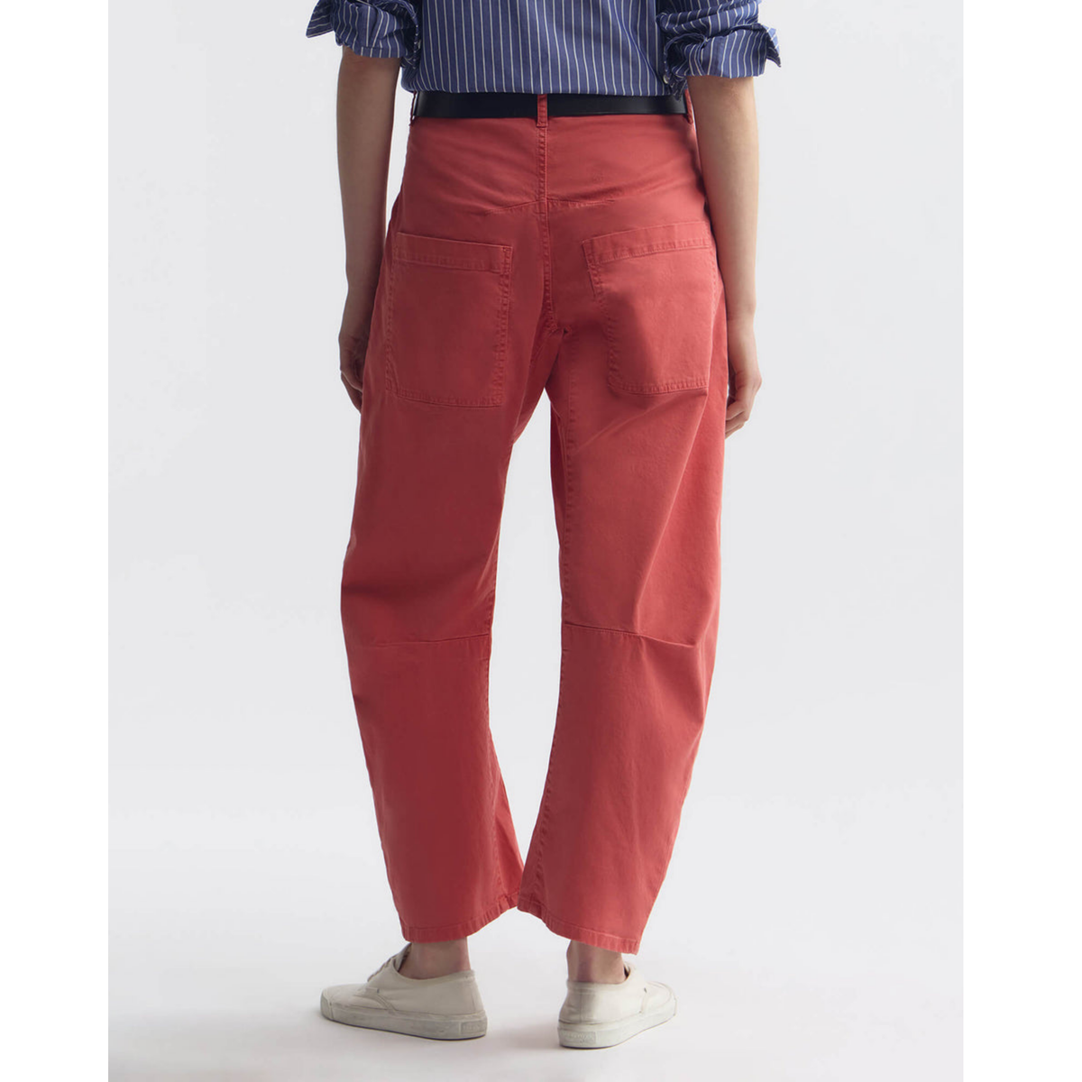 Person wearing red pants and a striped shirt on a white background