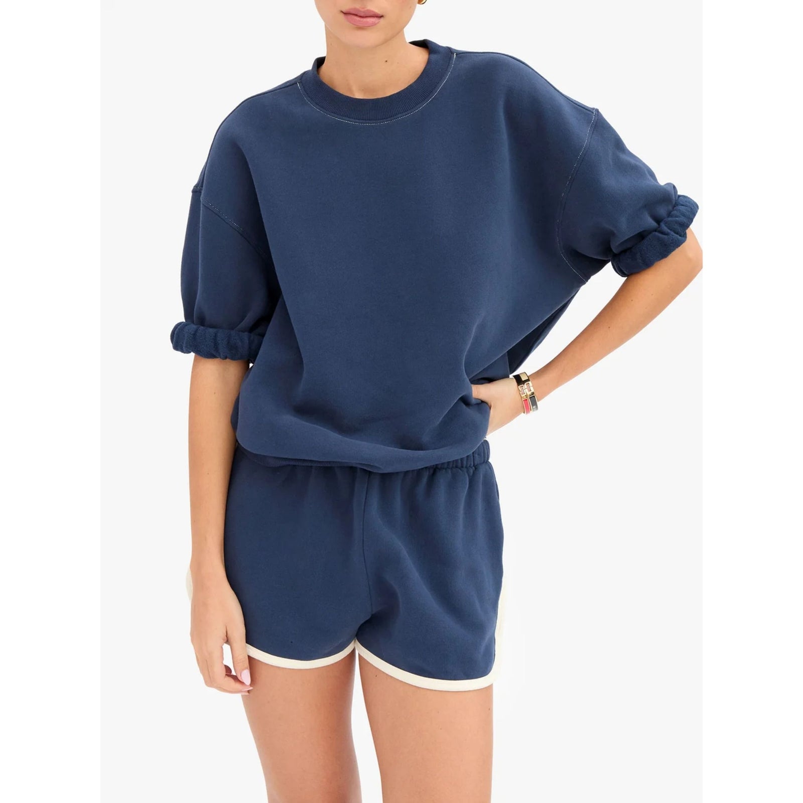 Front view of a model wearing the solid navy short-sleeve oversized sweatshirt styled with matching navy sweat shorts with white contrast trim.