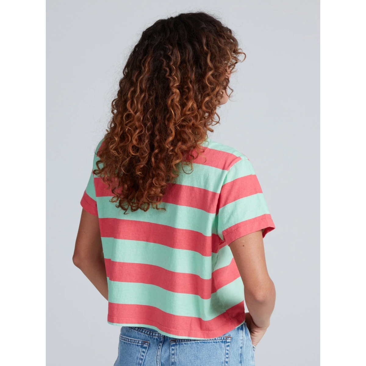 Person wearing a red and green striped shirt with a plain background