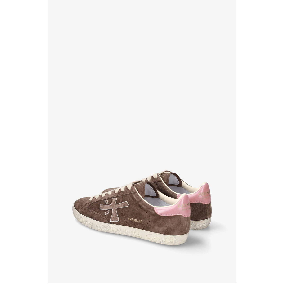 A pair of PREMIATA sneakers in brown suede with a pink heel tab, featuring the brand's signature cross logo on the side and a cream-colored sole.