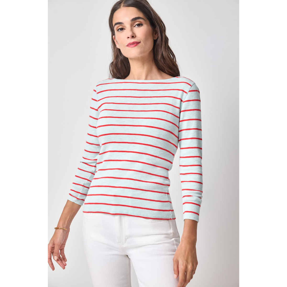Woman wearing a red and white striped sweater against a plain background