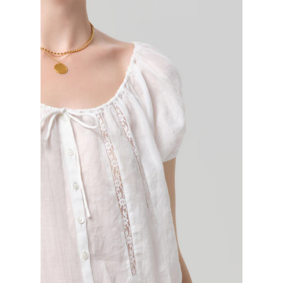 White blouse with lace details on a plain background