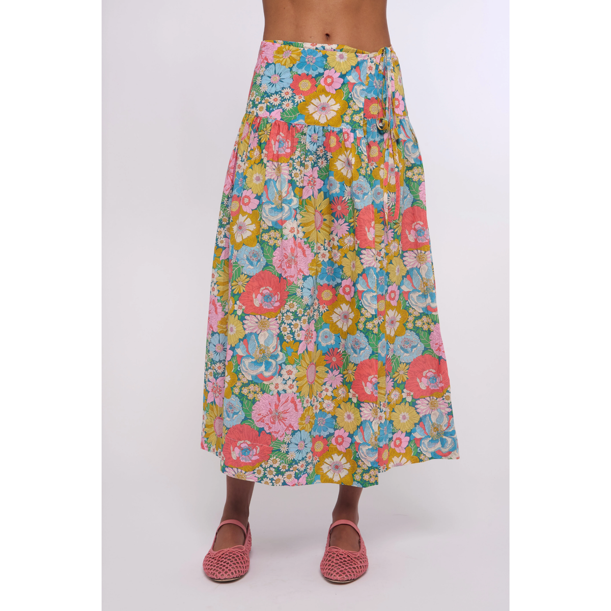 Colorful floral skirt worn by a person on a white background