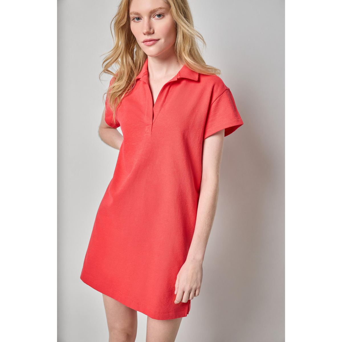 Woman wearing a red dress against a plain background