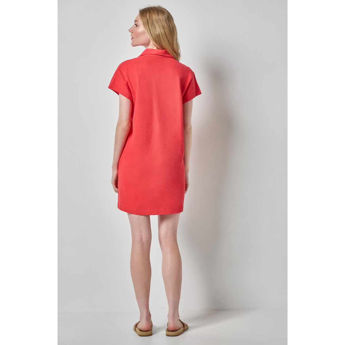 Woman wearing a red dress against a plain background