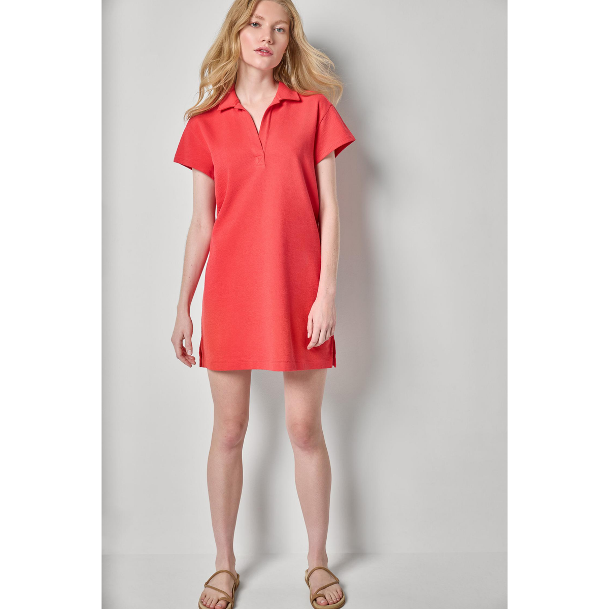 Woman wearing a red dress against a plain background